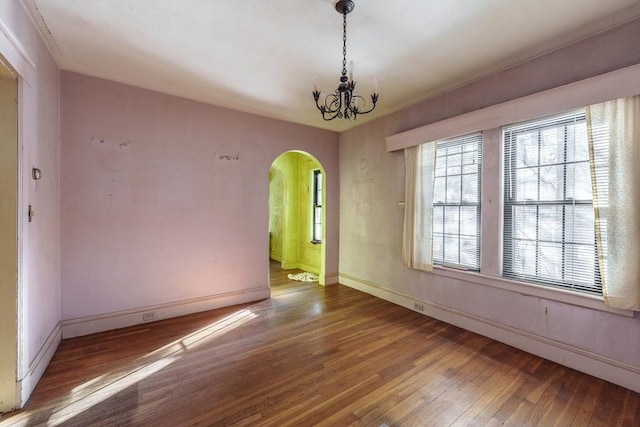 empty room featuring hardwood / wood-style floors and an inviting chandelier