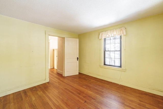 empty room featuring a textured ceiling and light wood-type flooring