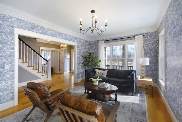 living room with an inviting chandelier, crown molding, and wallpapered walls