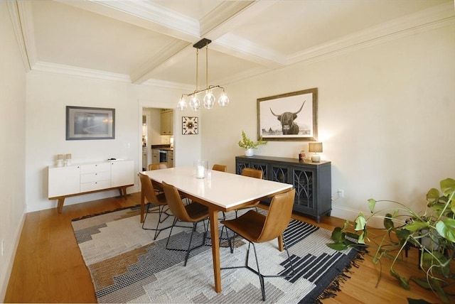 dining space with beamed ceiling, coffered ceiling, and wood finished floors