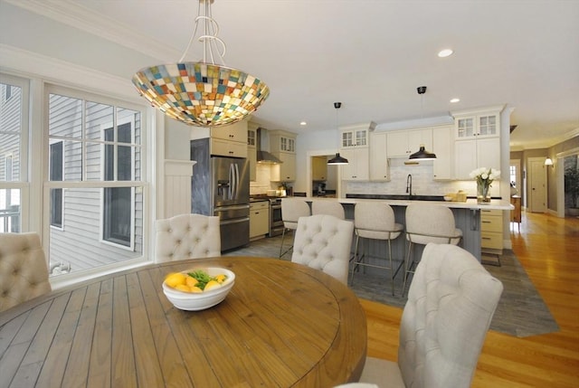 dining room with crown molding, recessed lighting, and wood finished floors