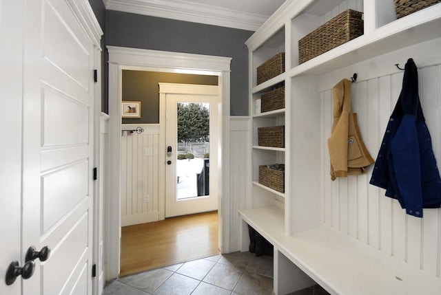 mudroom featuring light tile patterned flooring, wainscoting, and ornamental molding