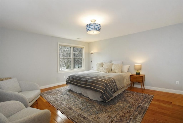 bedroom featuring baseboards and wood finished floors