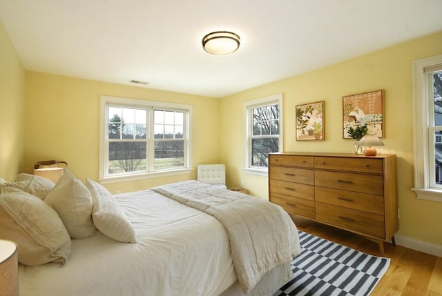 bedroom featuring visible vents, wood finished floors, and baseboards