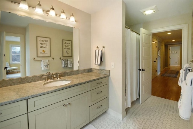 full bath featuring baseboards and vanity