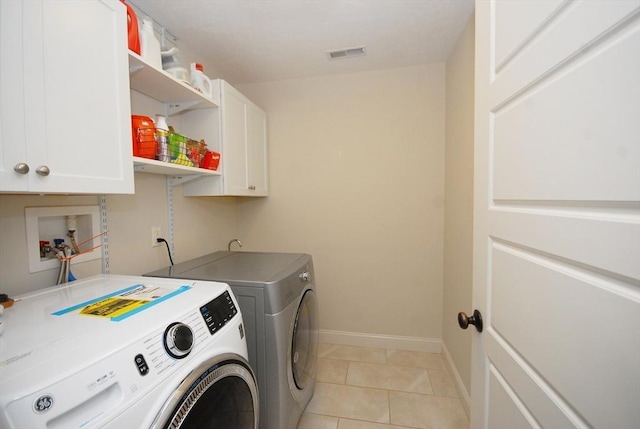 laundry room with visible vents, baseboards, light tile patterned flooring, cabinet space, and separate washer and dryer