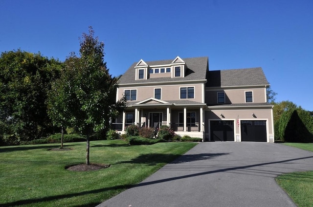 view of front of home featuring driveway, an attached garage, a porch, and a front lawn