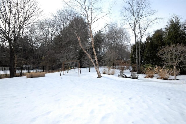 yard covered in snow featuring fence