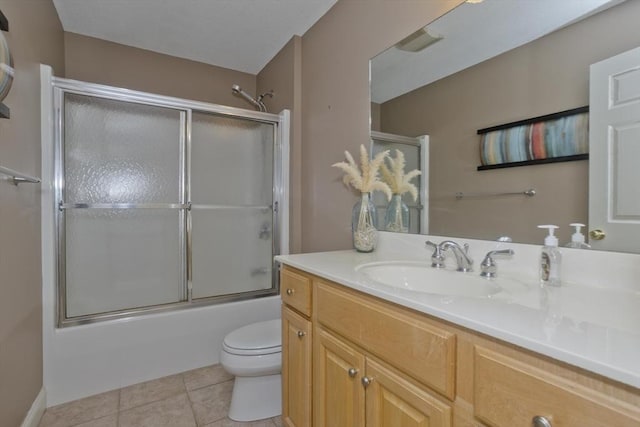 full bathroom featuring tile patterned flooring, vanity, shower / bath combination with glass door, and toilet