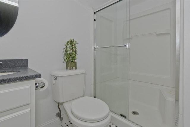 bathroom featuring vanity, a shower with door, and toilet