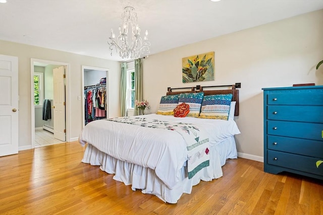 21 Boutwell, Andover, MA 01810 - bedroom with a chandelier, a baseboard heating unit, wood finished floors, a spacious closet, and a closet