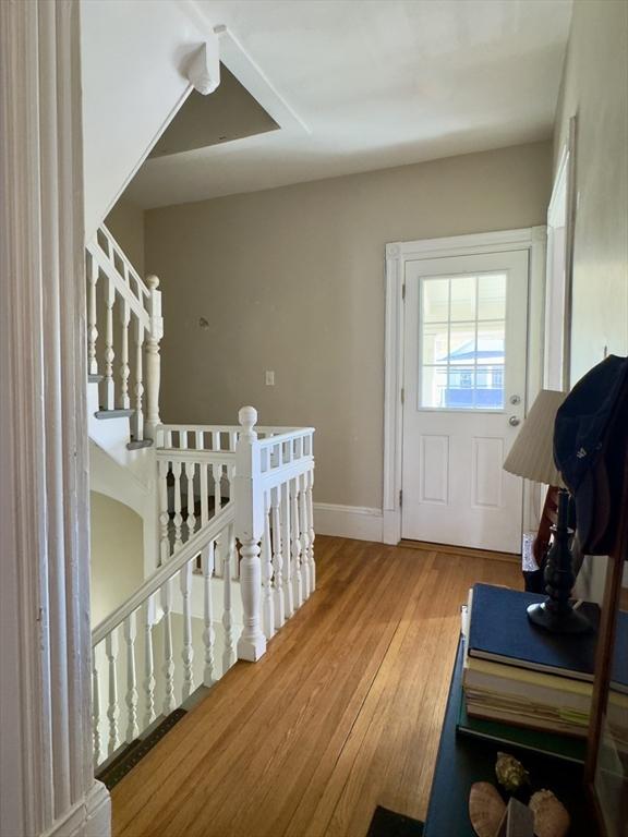 doorway to outside with baseboards and wood finished floors