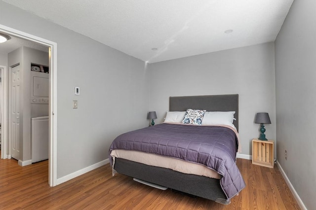 9 Adam St Unit 12, Easton, MA 02375 - bedroom with stacked washer and clothes dryer, wood finished floors, and baseboards