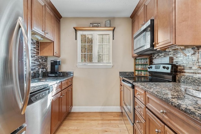 9 Adam St Unit 12, Easton, MA 02375 - kitchen featuring stainless steel appliances, a sink, light wood-type flooring, and backsplash