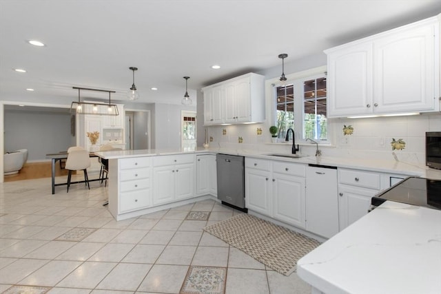 kitchen featuring dishwashing machine, a peninsula, a sink, and a wealth of natural light