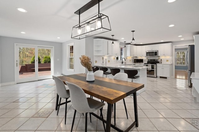 dining space with light tile patterned floors, baseboards, and recessed lighting