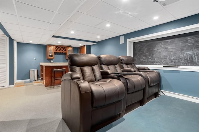 home theater featuring a paneled ceiling, light carpet, a bar, and recessed lighting