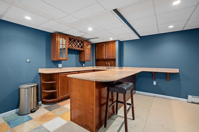 bar featuring wet bar, a drop ceiling, and baseboards