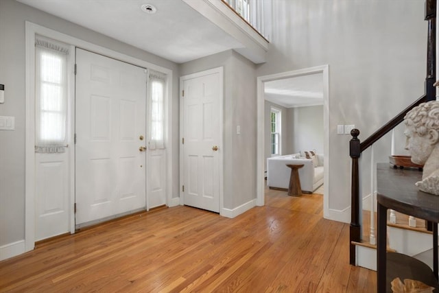 foyer entrance featuring light wood-style flooring and baseboards