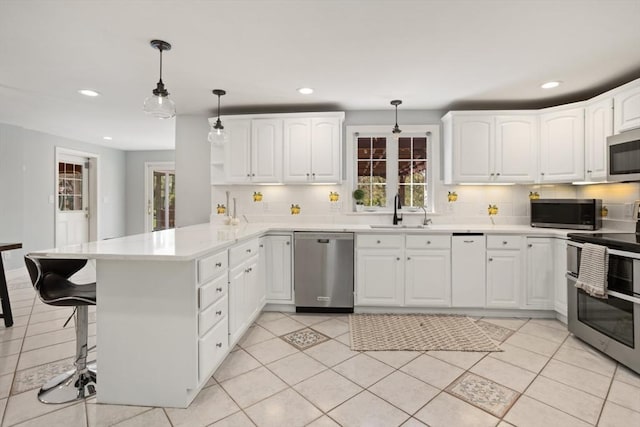 kitchen with a peninsula, stainless steel appliances, and recessed lighting