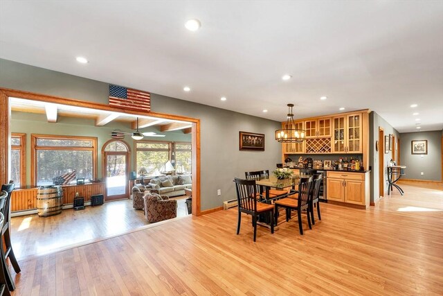 dining area with light wood-type flooring, bar, baseboards, and recessed lighting