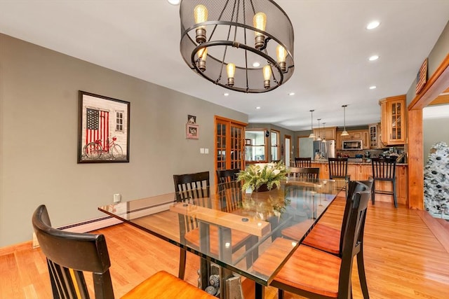 dining space featuring a baseboard radiator, light wood-style flooring, recessed lighting, a notable chandelier, and baseboards