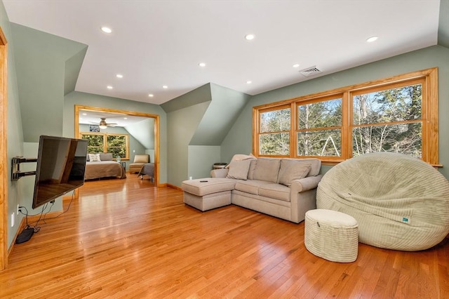 living area featuring lofted ceiling, light wood-style flooring, recessed lighting, visible vents, and baseboards