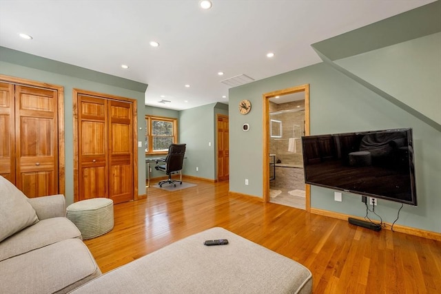 living area with light wood-type flooring, visible vents, and recessed lighting