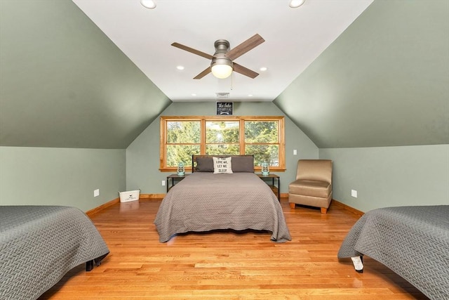 bedroom featuring ceiling fan, vaulted ceiling, baseboards, and wood finished floors