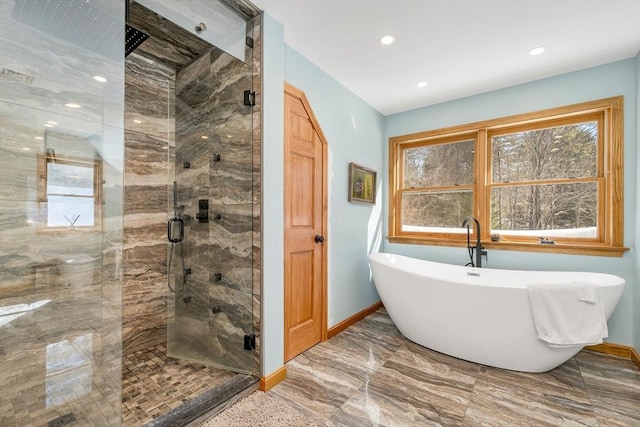 bathroom featuring baseboards, marble finish floor, a freestanding tub, a shower stall, and recessed lighting