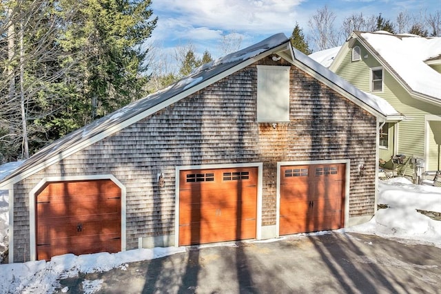 snow covered property featuring aphalt driveway