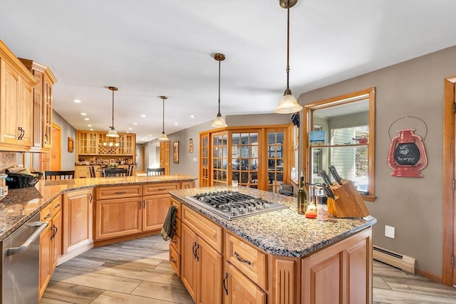 kitchen featuring appliances with stainless steel finishes, a peninsula, light stone countertops, wood tiled floor, and a baseboard heating unit