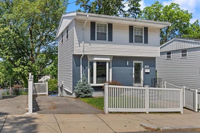 159 Glenellen Rd, Boston, MA 02132 - view of front of home featuring a fenced front yard, brick siding, and concrete driveway