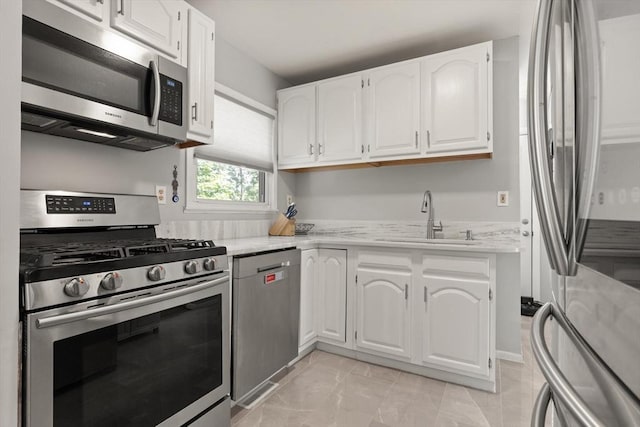159 Glenellen Rd, Boston, MA 02132 - kitchen featuring appliances with stainless steel finishes, white cabinets, light stone counters, and light tile patterned floors