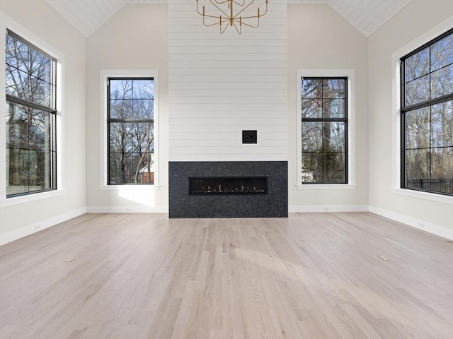 108 Glen St, Natick, MA 01760 - unfurnished living room with vaulted ceiling, wood finished floors, a fireplace, and healthy amount of natural light