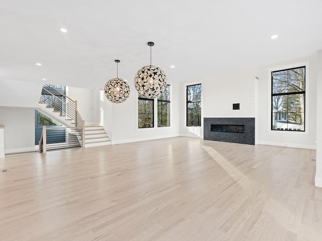 108 Glen St, Natick, MA 01760 - unfurnished living room with stairs, plenty of natural light, light wood-type flooring, and recessed lighting