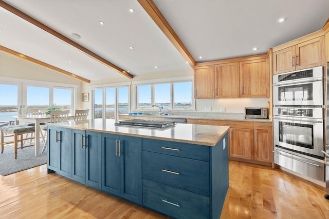 kitchen with a warming drawer, appliances with stainless steel finishes, plenty of natural light, light wood-style floors, and recessed lighting