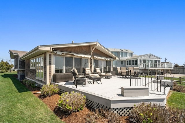 back of property with a deck, an outdoor living space, a lawn, and central air condition unit