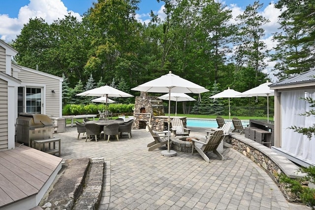 46 Baldpate Rd, Boxford, MA 01921 - view of patio featuring outdoor dining area, an outdoor fire pit, an outdoor pool, an outdoor kitchen, and view of wooded area