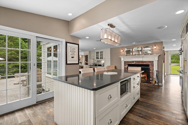 46 Baldpate Rd, Boxford, MA 01921 - kitchen featuring dark countertops, a fireplace, stainless steel microwave, open floor plan, and dark wood-style flooring