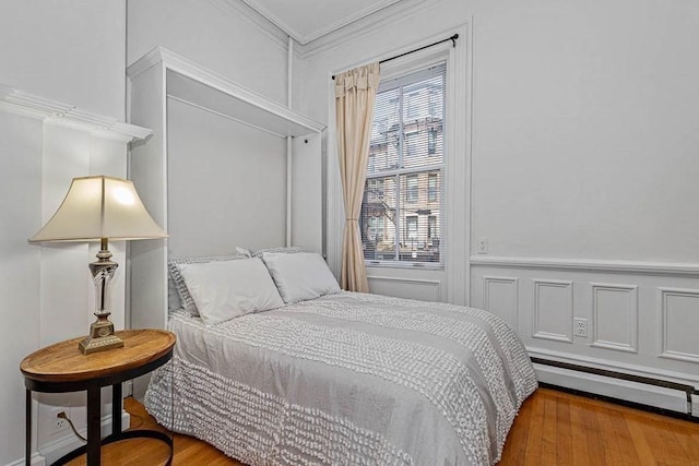 227 Marlborough St Unit 4, Boston, MA 02116 - bedroom featuring crown molding, wood finished floors, a wainscoted wall, and a baseboard heating unit