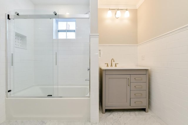 bathroom with wainscoting, bath / shower combo with glass door, vanity, and ornamental molding