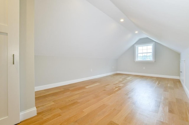 bonus room with vaulted ceiling, light wood-style floors, baseboards, and recessed lighting