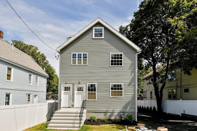 rear view of house featuring fence