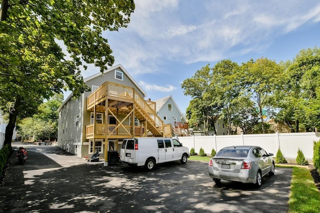 view of front of property featuring fence and stairway
