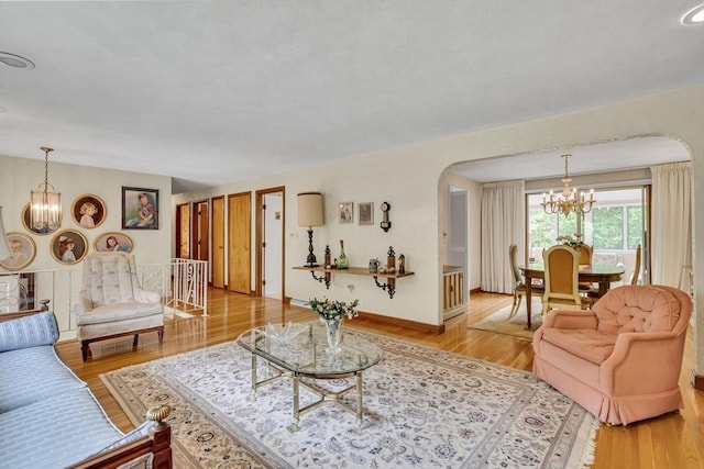 27 Philip Rd, Lexington, MA 02421 - living room with a chandelier, arched walkways, and wood finished floors