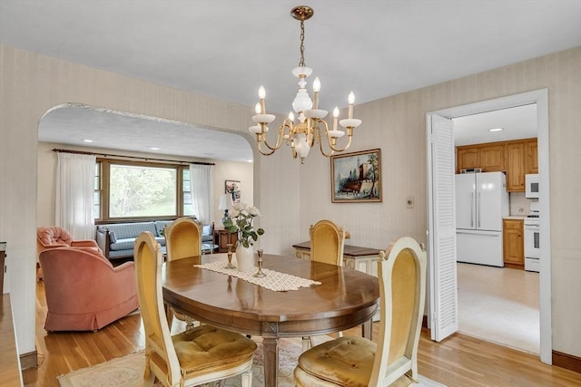 27 Philip Rd, Lexington, MA 02421 - dining area with light wood finished floors, a chandelier, wallpapered walls, and arched walkways