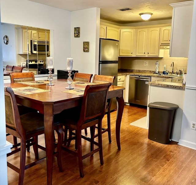 dining area with light hardwood / wood-style floors and sink