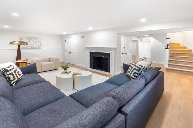 271 Greenwood St, Newton, MA 02459 - living area featuring recessed lighting, light wood-style floors, stairway, baseboard heating, and a fireplace with flush hearth