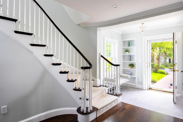 271 Greenwood St, Newton, MA 02459 - staircase with wood finished floors, healthy amount of natural light, crown molding, built in shelves, and baseboards